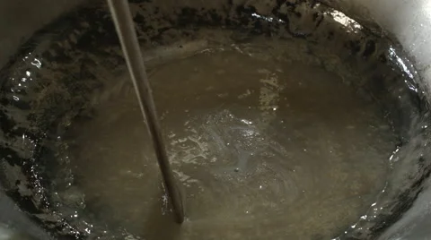 Stirring syrup, sugar, coconut milk and cream to make  Vietnamese coconut  candy Stock Footage 48147357