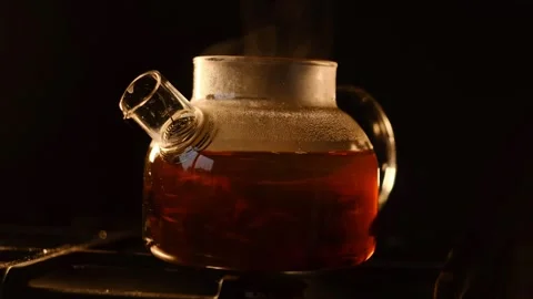 Stirring Tea in a Glass Teapot, Creating a Dance of Leaves in Hot Water, under w Stock Footage 295209340