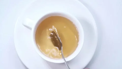 Stirring Tea: White Cup and Saucer with Spoon Stock Footage 343658147