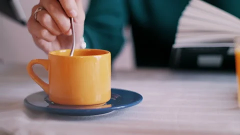 Stirring tea in yellow cup Video stock 131184834