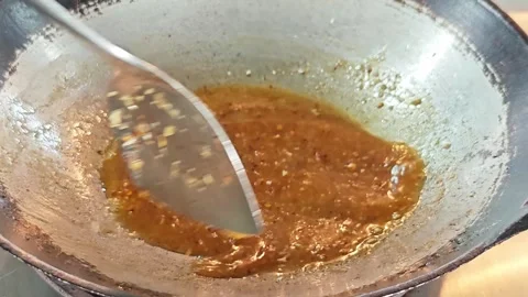 Stirring a thick and glossy Pad Thai sauce base in a wok close up. Stockbeeldmateriaal 339186551