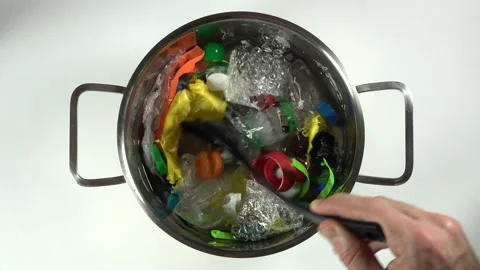 Stirring through 'plastic soup', pan with disposed waste garbage litter Stock Footage 143315581