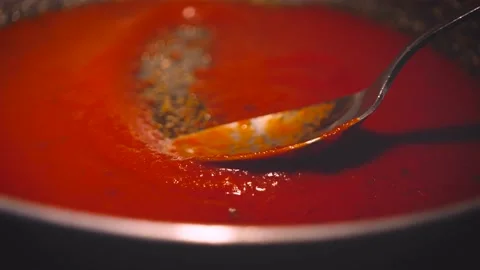 Stirring tomato sauce on the pan with table spoon, close up. Cooking tomato  Stock Footage 143248910