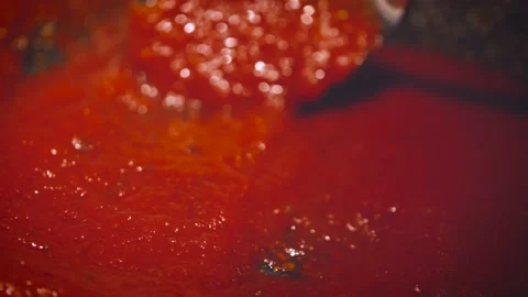 Stirring tomato sauce on the pan with table spoon, close up. Cooking tomato  Stock Footage 143248944