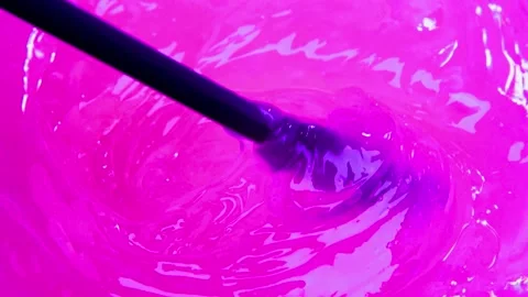 Stirring vibrant pink liquid with dark spoon, creating swirling texture motio Stock-Footage 342905253