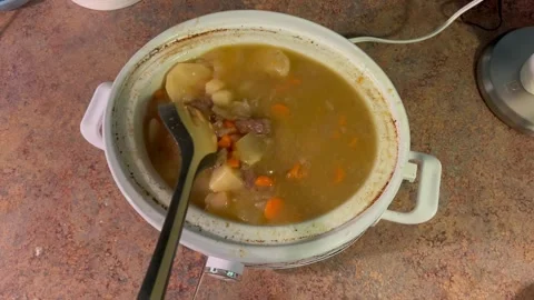 Stirring Warm Beef Stew and Vegetables in Slow Cooker 库存影片 345754580
