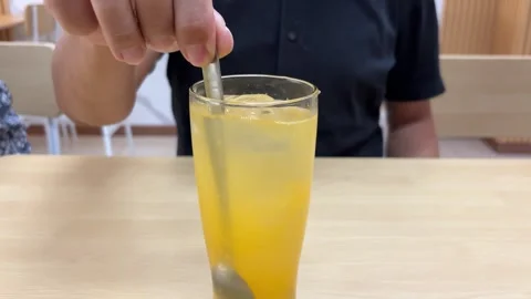 Stirring Yellow Beverage with Spoon Stock Footage 311354012