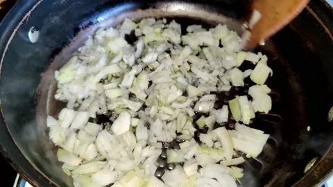 Stirs the onion, which is fried in a pan with vegetable oil Stock Footage 227721594