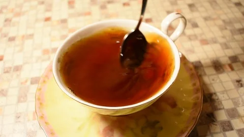 Stirs sugar into a cup of tea Stock Footage 122681482