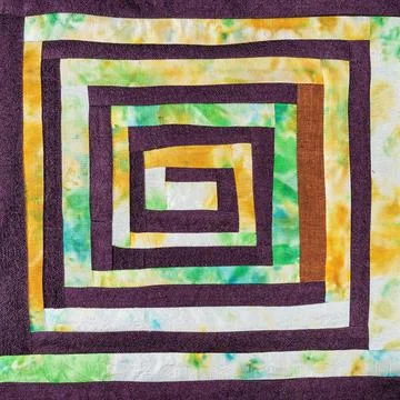 Stitched patchwork fabric with yellow spiral Foto stock