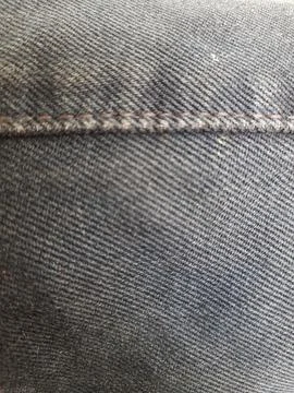 The stitching and texture of the old grayish black jeans Foto stock