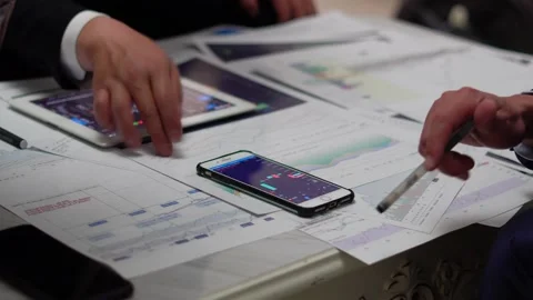 Stock analysts discuss and study the company's financial statement performan Stock Footage 154535584