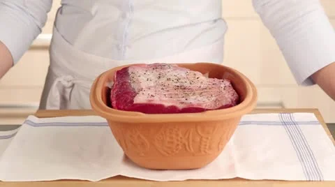 Stock and white wine being added to beef in a terracotta baking dish 스톡 동영상 24657393