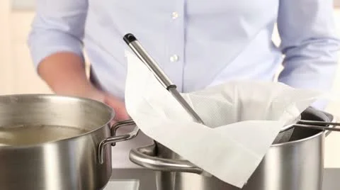 Stock being poured through a sieve lined with kitchen paper Stock Footage 24658101