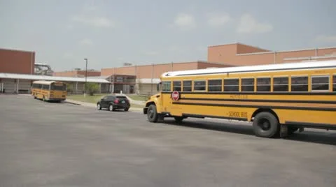 Stock Footage - School Bus pulls into school - Wide - Students Stock Footage 11131456