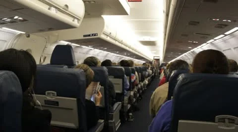 Stock - HD 1080p - Passengers sitting in rows on a plane in flight Stock Footage