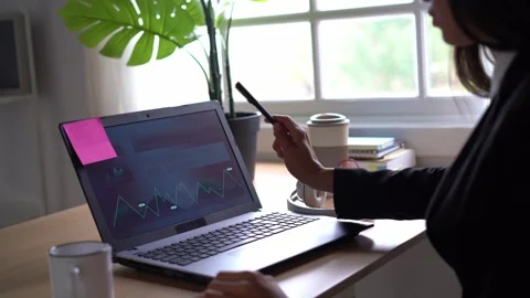 Stock trader analyzing chart on laptop in office Stock Footage 269344404