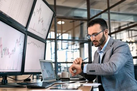 Stock trader checking time and working in office Stock Photos