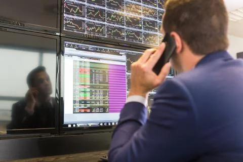 Stock trader looking at computer screens. Stock Photos
