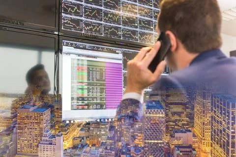 Stock trader looking at computer screens. Businessman with cell phone trad... Foto stock