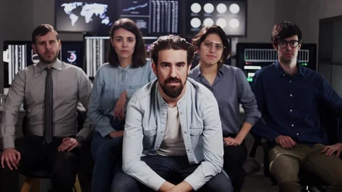 Stock trader teamwork looking at camera against multiple monitors Stock Footage 310505817