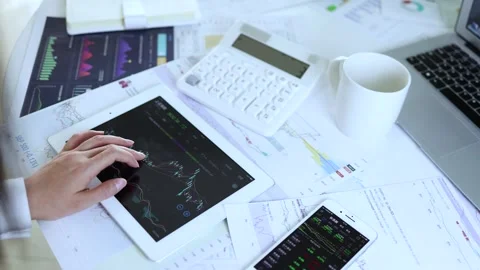Stock trader using computer and mobile phone to watch market and analyze sto Stock Footage 245249354