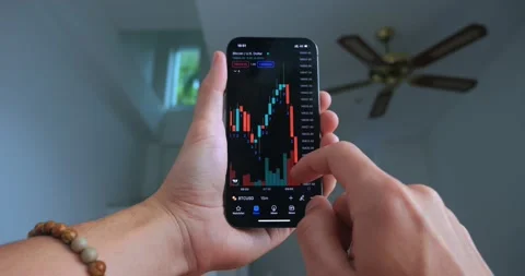 Stock trader using smart phone app analyzing financial data crypto stock market Stock Footage 229688863