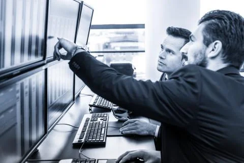 Stock traders looking at market data on computer screens. Foto stock