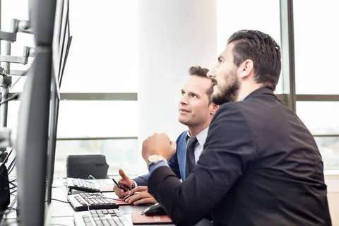 Stock traders looking at market data on computer screens. Successful busin... Foto stock