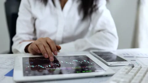 Stock traders use tablets to trade stocks Stock Footage 168963773
