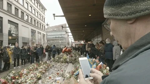 Stockholm terror attack: man taking photo with telephone at final crash site Stock Footage