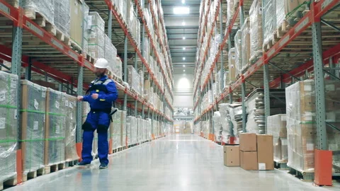 Stockhouse worker in ergoskeleton is lifting heavy boxes Stock Footage 163522164