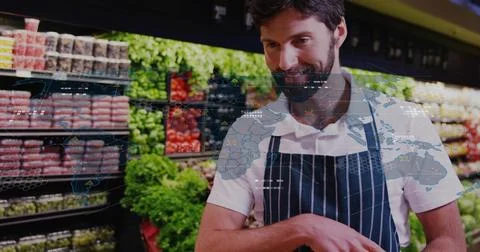 Stocking man in striped apron sorting produce in produce aisle with digital Stock Photos