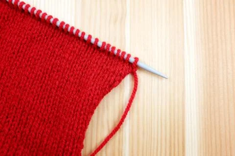 Stocking stitch in red wool on a knitting needle Stock Photos