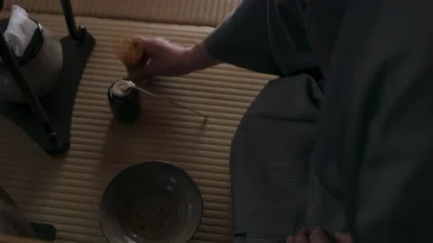 Stoic male tea master preparing a bowl of tea during a tea ceremony in a traditi Stock Footage 199457391