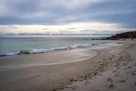 Stokes Bay Beach at sunset with waves and rocks, Australia Stock Photos