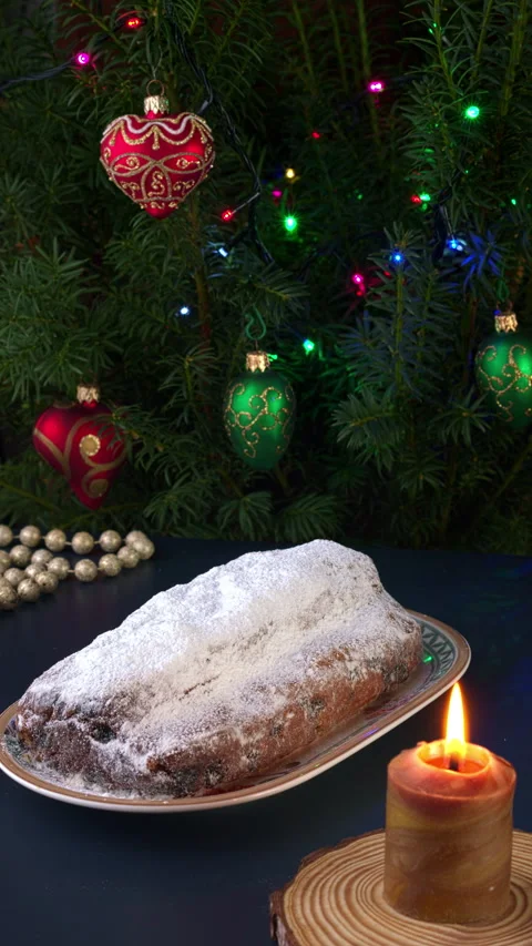 Stollen cake on a Christmas table with burning wax candle. Vertical video. Stock Footage 284309523