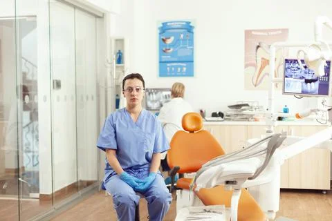 Stomatological nurse looking into camera while waiting for senior doctor Stockfoto's