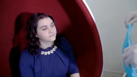 Stomatologist adjusting bib while patient sit in chair Stock Footage 106094413