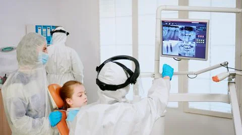 Stomatologist in coverall explaining dental problem using digital monitor 스톡 사진