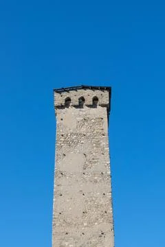 Stone ancient rectangular tower against the blue sky. 스톡 사진