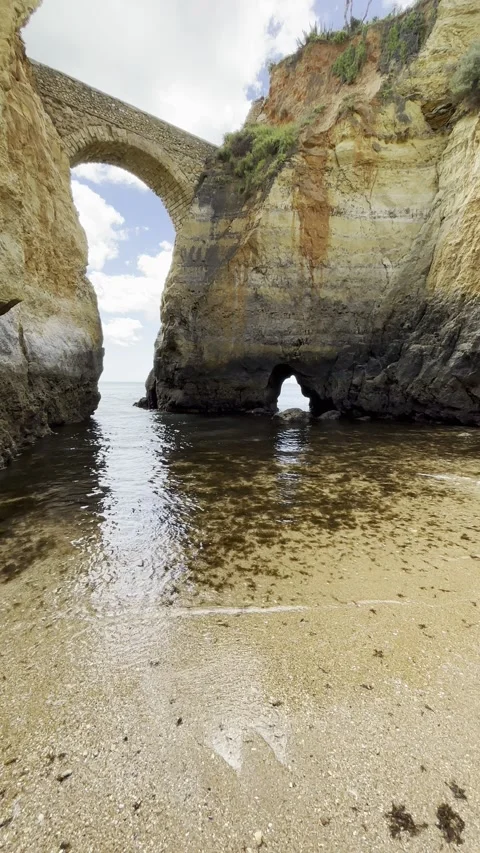Stone Arch between Coastal Cliffs at the Atlantic Ocean – Lagos, Portugal Stock Footage 310047339