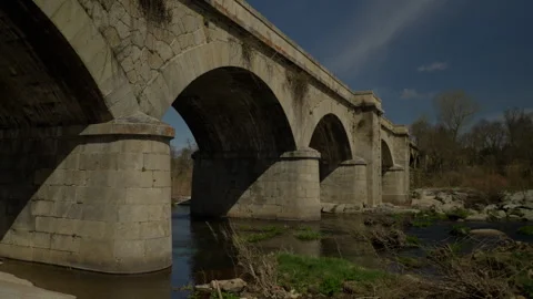 Stone arch bridge connecting river banks Stock Footage 335462070