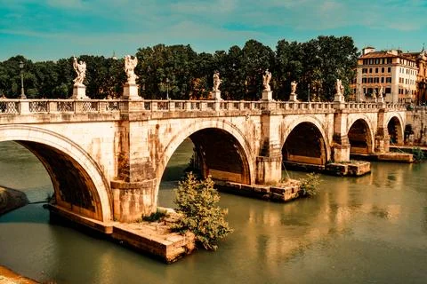 A stone arch bridge lined with Roman statues Stock Photos