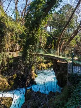 Stone arch bridge over a fast mountain river with a strong current. Clear tur Foto stock