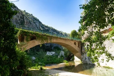 Stone Arch Bridge Over River in Pantalica Canyon Stock Photos