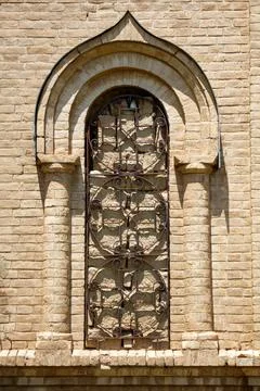 Stone arch frames ornate, wrought-iron window Stock Photos