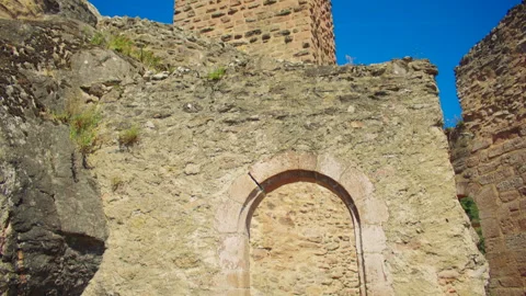Stone arch within medieval castle ruins framing landscape Stock Footage 327569073