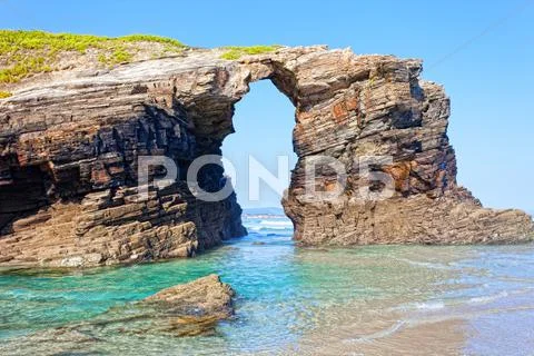 Stone Arches On Playa De Las Catedrales During Outflow, Spain