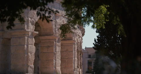 Stone arches of Pula Arena framed by trees Vídeos de archivo 334690636